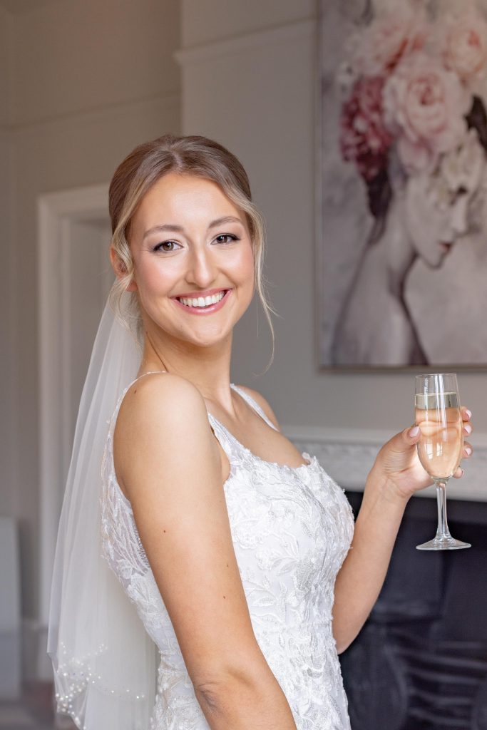 Very happy bride smiling with champagne